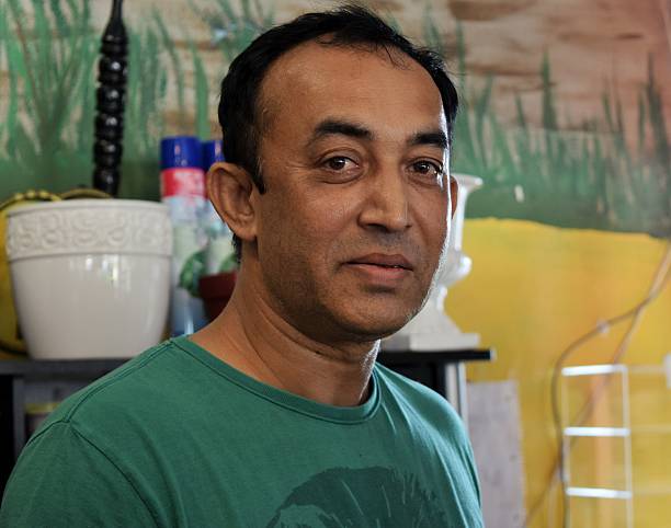 Mid adult man from Bangladesh, owns a local convenience and flower shop
